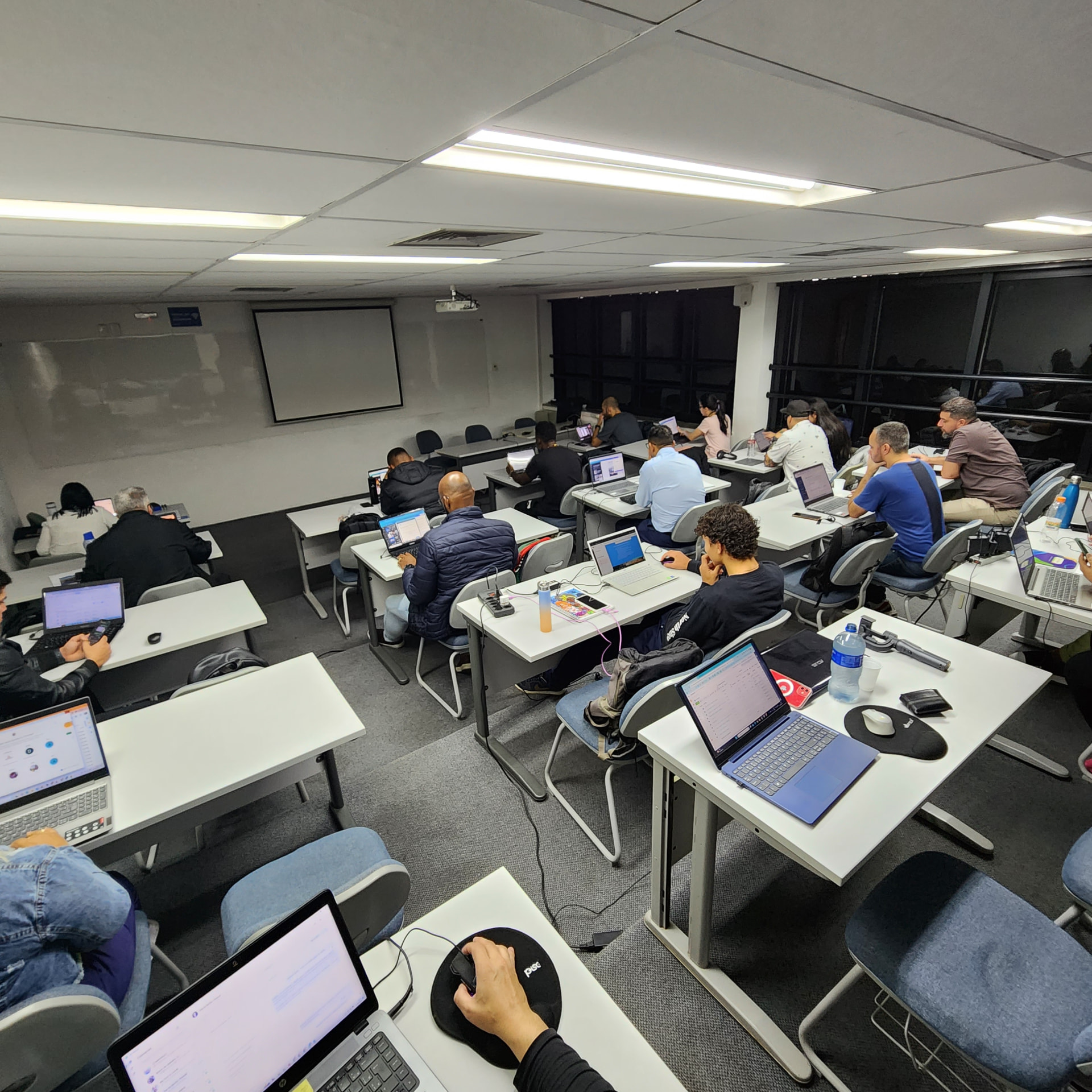 Alunos praticando em notebooks durante a imersão presencial.